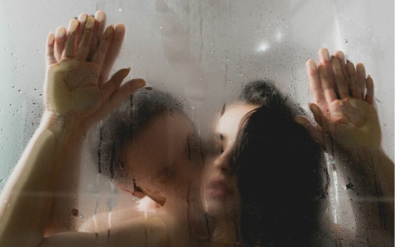 Sexuálne polohy v sprche - muž so ženou za zahmleným sklom sprchy